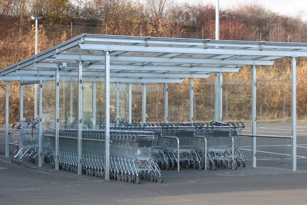 Einkaufswagen-Unterstand mit Metallkonstruktion auf Asphalt – stabile Befestigung mit Asphaltschrauben