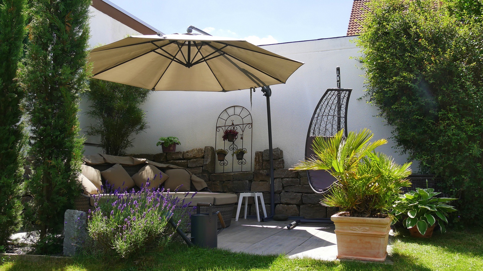Gartenterrasse mit Sonnenschirm und Lounge | Schallschutzzaun